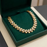 Collar de perlas con hojas doradas
