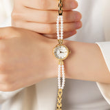 Reloj dorado con cuentas perladas